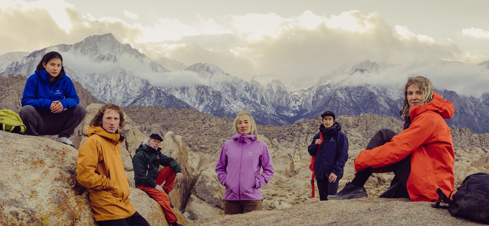 The Beta Family — Arc'teryx athletes and staff gathered on granite boulders in the Eastern Sierra at dusk